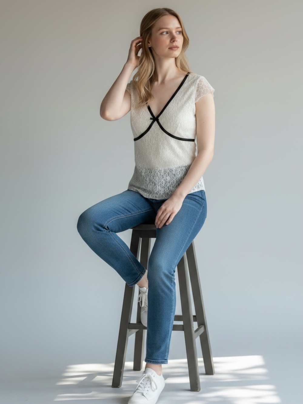 Cream lacy top with black outline and bow.